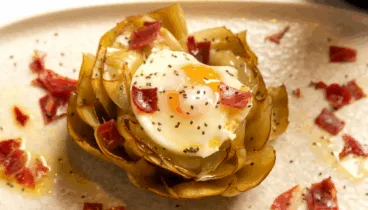 Deliciosa flor de alcachofa con huevo poche y jamón
