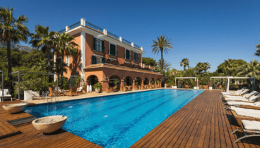 Vista general del hotel con piscina y jardines mediterráneos