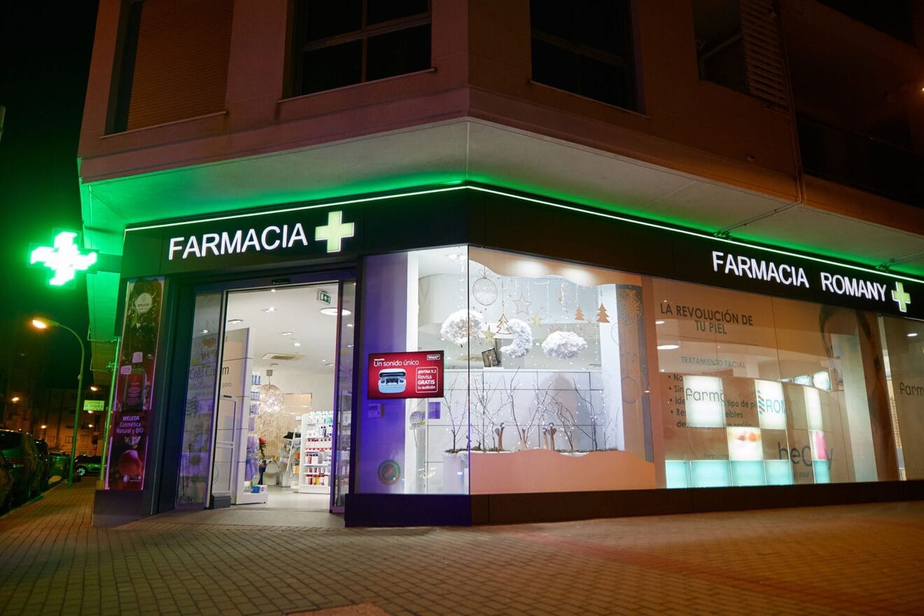 Fachada de noche de Farmacia Romany Romany