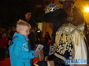 Un niño entrega su carta al Cartero Real