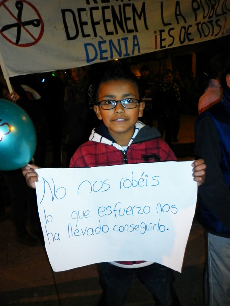 Un niña sujeta una pancarta contra los recortes en educación