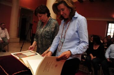 Ana Kringe y Pepa Font mirando el facsímil del Título de Ciudad
