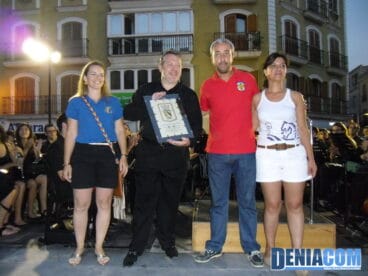 El presidente de la AMMICC entrega una placa al director de la Banda de Dénia