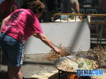 Los concursantes preparan el plato típico valenciano bajo la atenta mirada de los viandantes