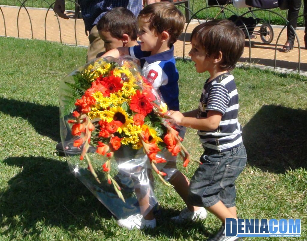 Niños realizando la ofrenda florar a la estatua de Jaume I en Dénia