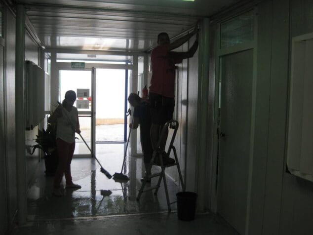 Profesores del colegio recogiendo agua el primer día de clases