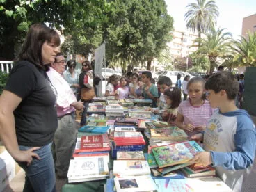 Niños de colegio participando en la recogida de libros por comida