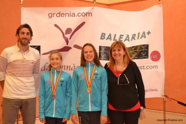 Les gimnasta posant junt al regidor d'esports i presidenta del CG
