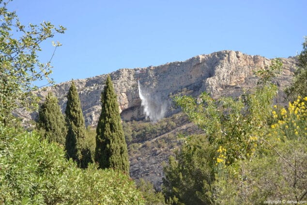 Un helicóptero tira agua para refrescar la zona incendiada