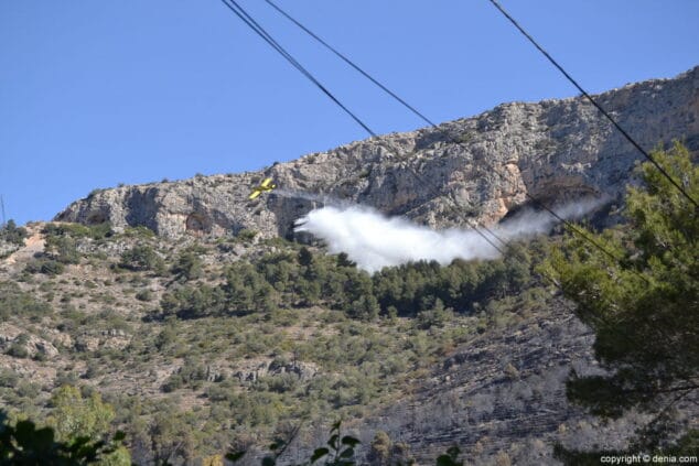 Una avioneta descargando agua sobre la zona incendiada