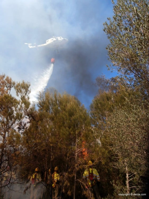 Uno de los helicópteros dejando caer agua sobre las llamas