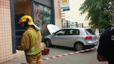 Un bombero vigila el lugar donde esta el coche