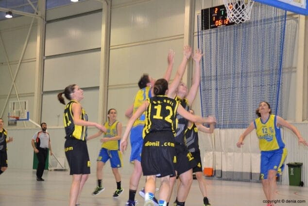 Lucha por un rebote en el partido Dénia Básquet CD