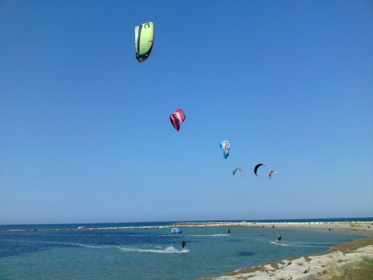 Gente praticando kite surf en una playa de Dénia