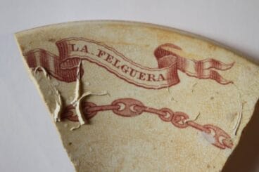 Inscripción de La Felguera en un fragmento de loza