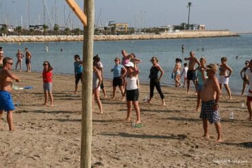 De todas las edades van a las clases de deporte en la playa