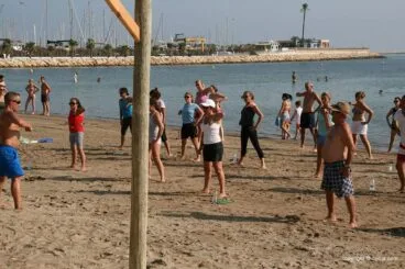 De todas las edades van a las clases de deporte en la playa