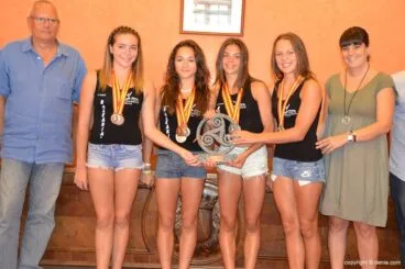 Las gimnastas con las medallas y el trofeo