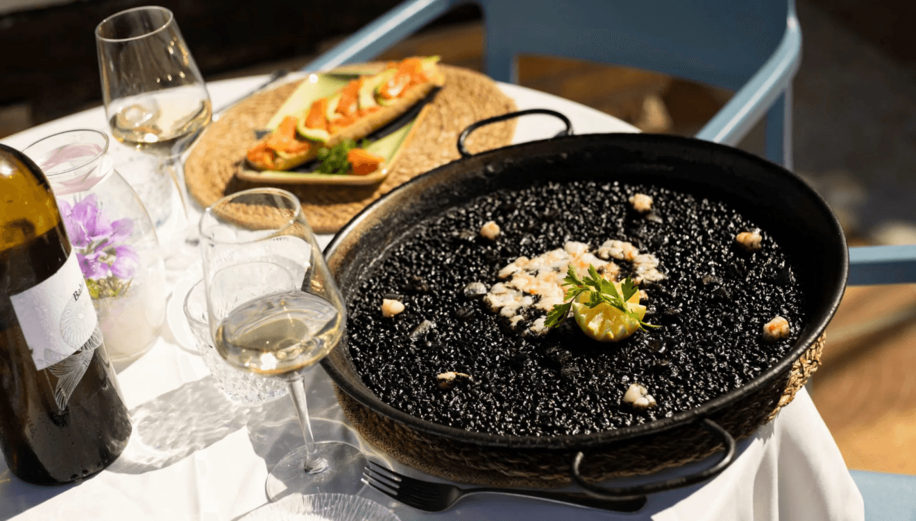 Experiencia gastronómica mediterránea frente a las embarcaciones del puerto