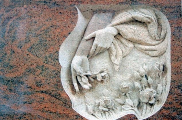 detalle lápida manos y flores
