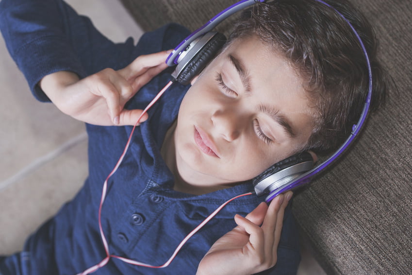 Music therapy concept. Boy relaxing while listening to music