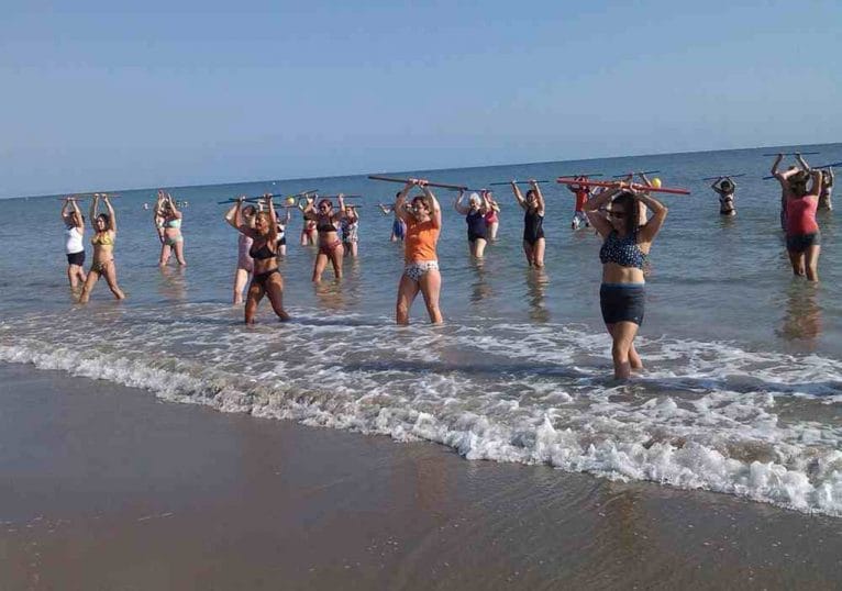 Gente realizando un ejercicio en la playa de Dénia