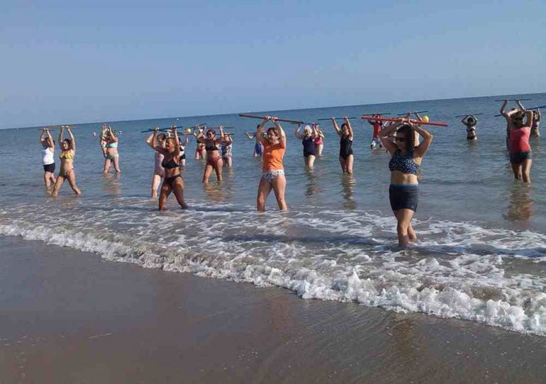 Gente realizando un ejercicio en la playa de Dénia