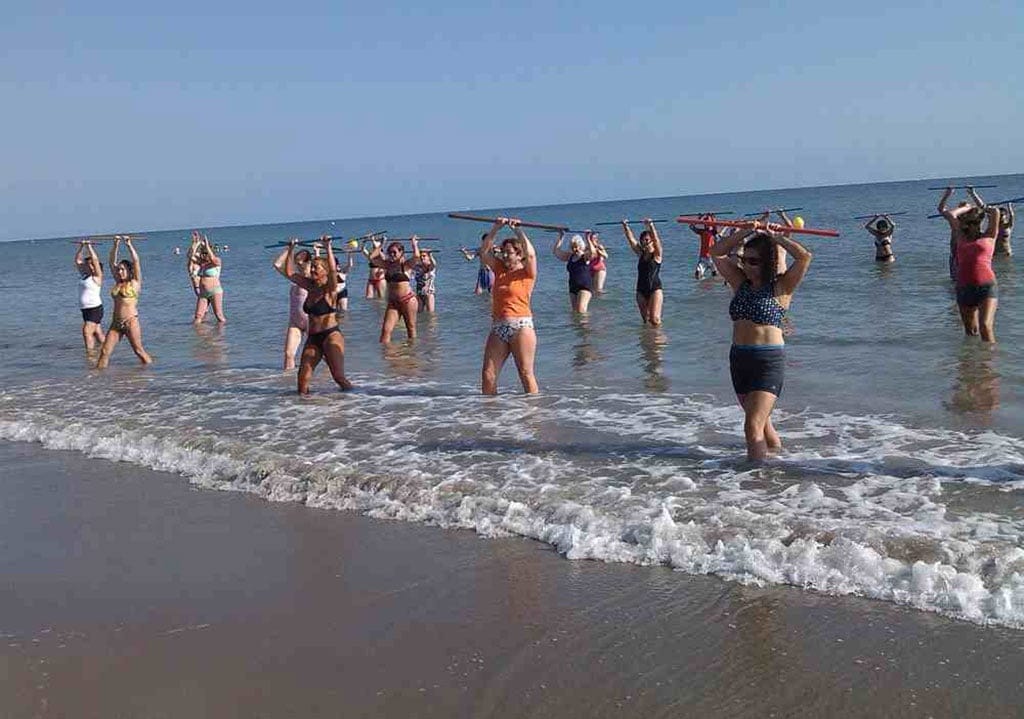 Gente realizando un ejercicio en la playa de Dénia