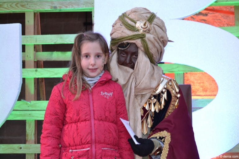 Visita de los Carteros Reales a Dénia - nena con uno de los carteros