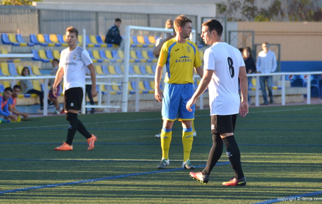 jordi entre dos jugadores de la ud carcaixent