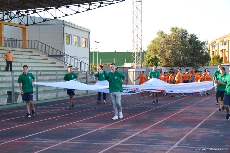 Volunteers carrying the Olympic flag