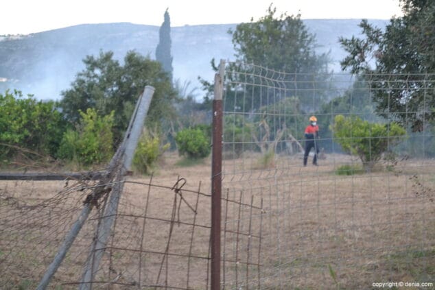El incendio en una parcela del camino del Cementario obliga a cortar la carretera y evacuar las naves falleras 3 bombero sofocando el fuego