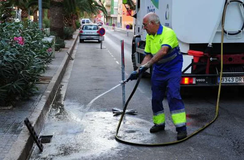 Operario limpiando imbornales en una calle de Dénia