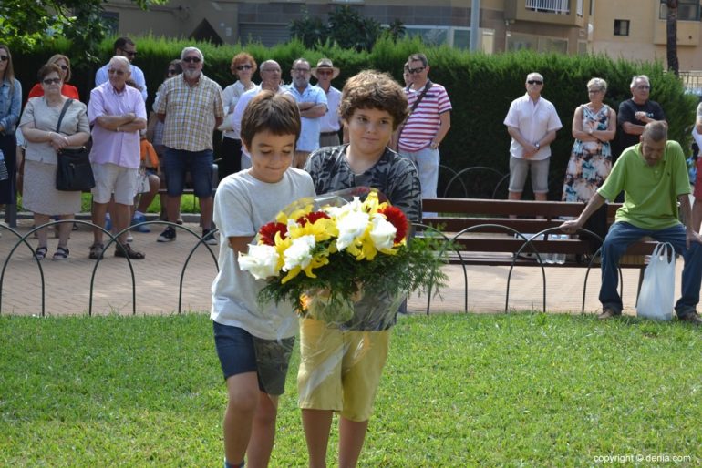 9 d'Octubre Compromís per Dénia - Dos niños hacen la ofrenda de flores a la estatua
