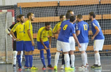 jugadores de ambos equipos rodeando a uno de los arbitros