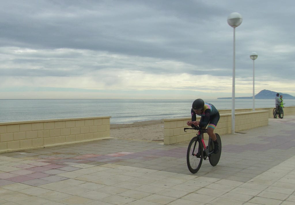 ciclista en plena contra reloj en el paseo maritimo de bellreguard