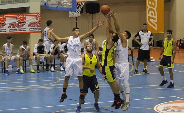 un jugador senior del denia basquet luchando por el rebote