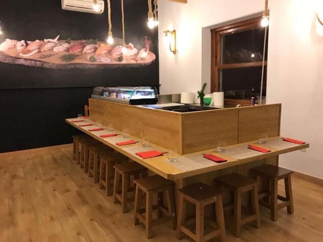 Disfruta de lunes a viernes de un menú delicioso con varios platos de sushi en Sushiber 5 mesa junto a cocina sushiber