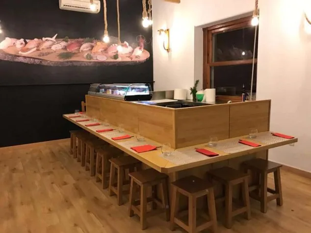 Disfruta de lunes a viernes de un menú delicioso con varios platos de sushi en Sushiber 5 mesa junto a cocina sushiber
