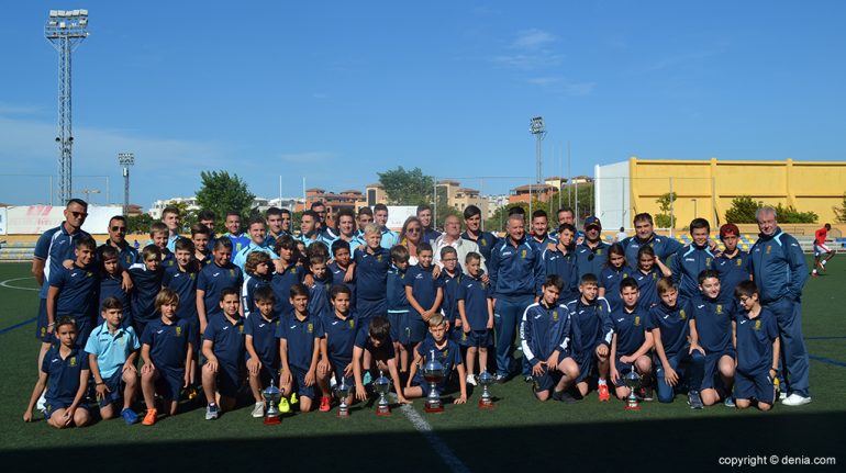 Equipos de la Escuela Municipal Fútbol Base Dénia con sus trofeos