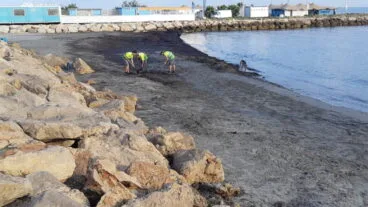 operarios limpiando la playa