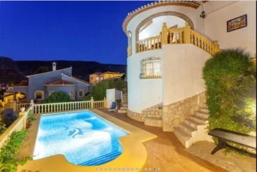 piscina y fachada noche vacation villas