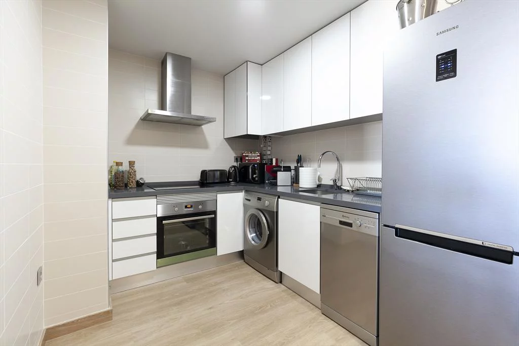 Cocina abierta con electrodomésticos modernos en apartamento de alquiler – Quality Rent a Villa