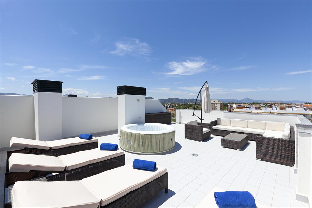 Terraza con tumbonas y jacuzzi en apartamento de alquiler vacacional en Dénia – Quality Rent a Villa