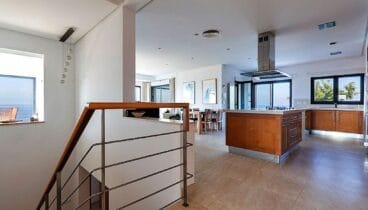 Cocina y escalera interior que conecta las cuatro plantas de un chalet en Las Rotas – Euroholding