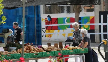 Clientes en un puesto de verduras