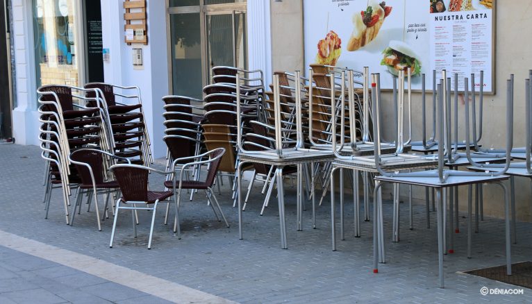 Sillas y mesas apiladas en una terraza de la calle La Mar