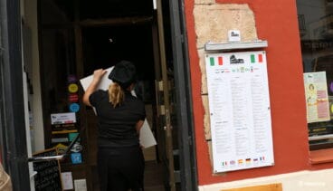 Trabajadora recogiendo una mesa