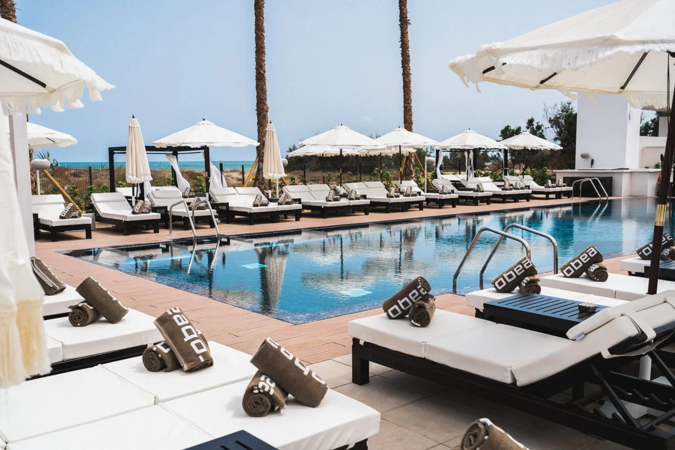 Piscina con tumbonas y parasoles en Purobeach Dénia