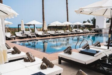 Piscina con tumbonas y parasoles en Purobeach Dénia